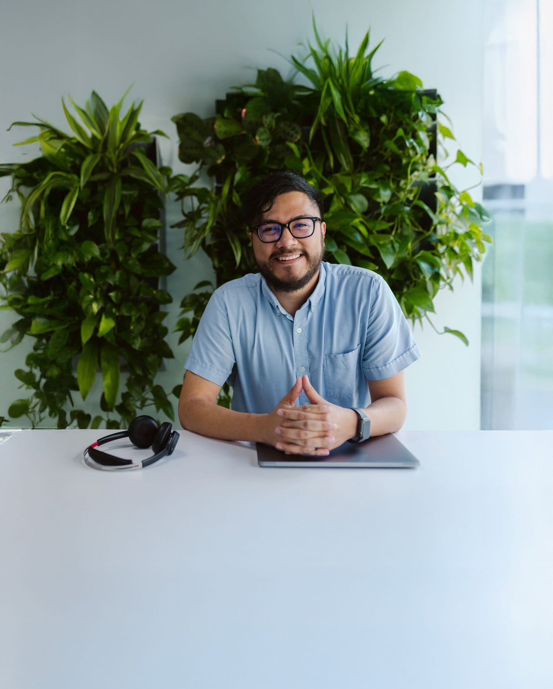 WP Engine support team member smiling with hands folded over laptop ready to help
