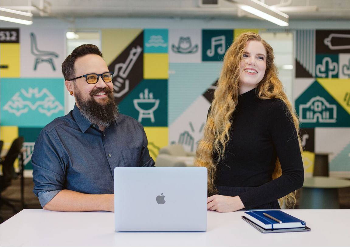 austin texas hub with two people smiling in front of laptop