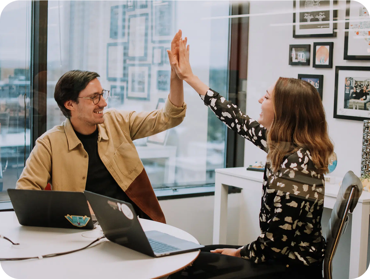 two people high-fiving in an office